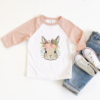 a white raglan tee with peach sleeves and a graphic of a bunny wearing a floral crown 