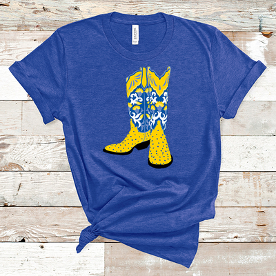 Blue shirt with a graphic of a pair of boots. The boots have a yellow ostrich print lower and he boot top is a blue white and yellow floral pattern with a yellow collar.