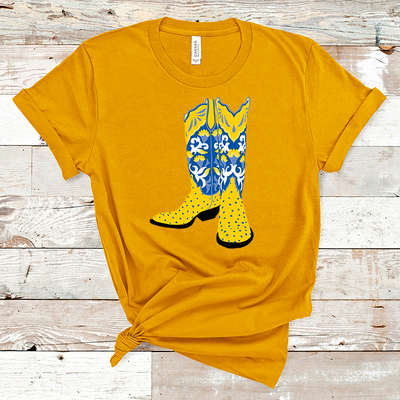 Mustard shirt with a graphic of a pair of boots. The boots have a yellow ostrich print lower and he boot top is a blue white and yellow floral pattern with a yellow collar.
